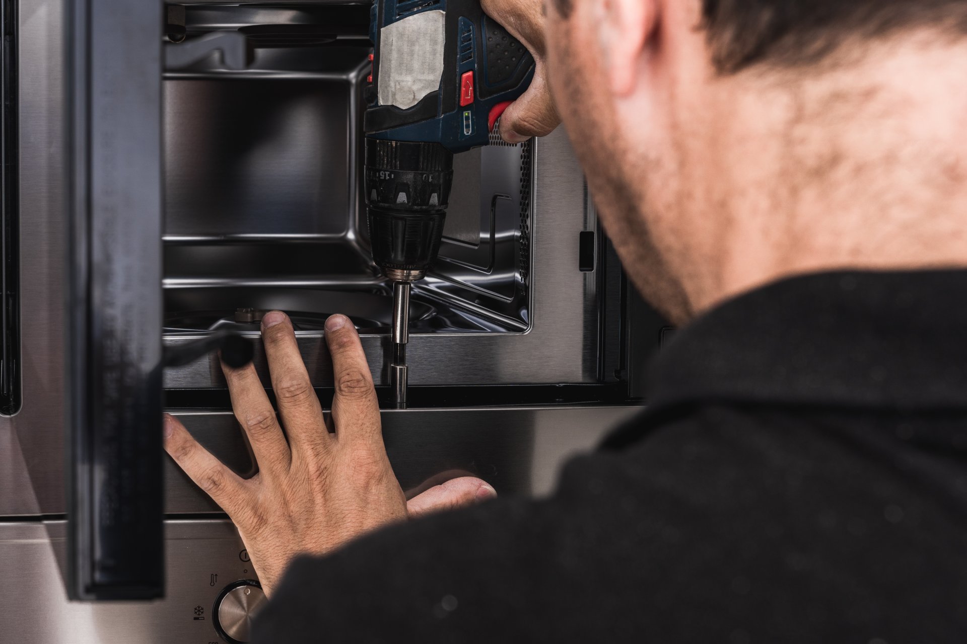 Person looking concerned at noisy dishwasher in Australian kitchen